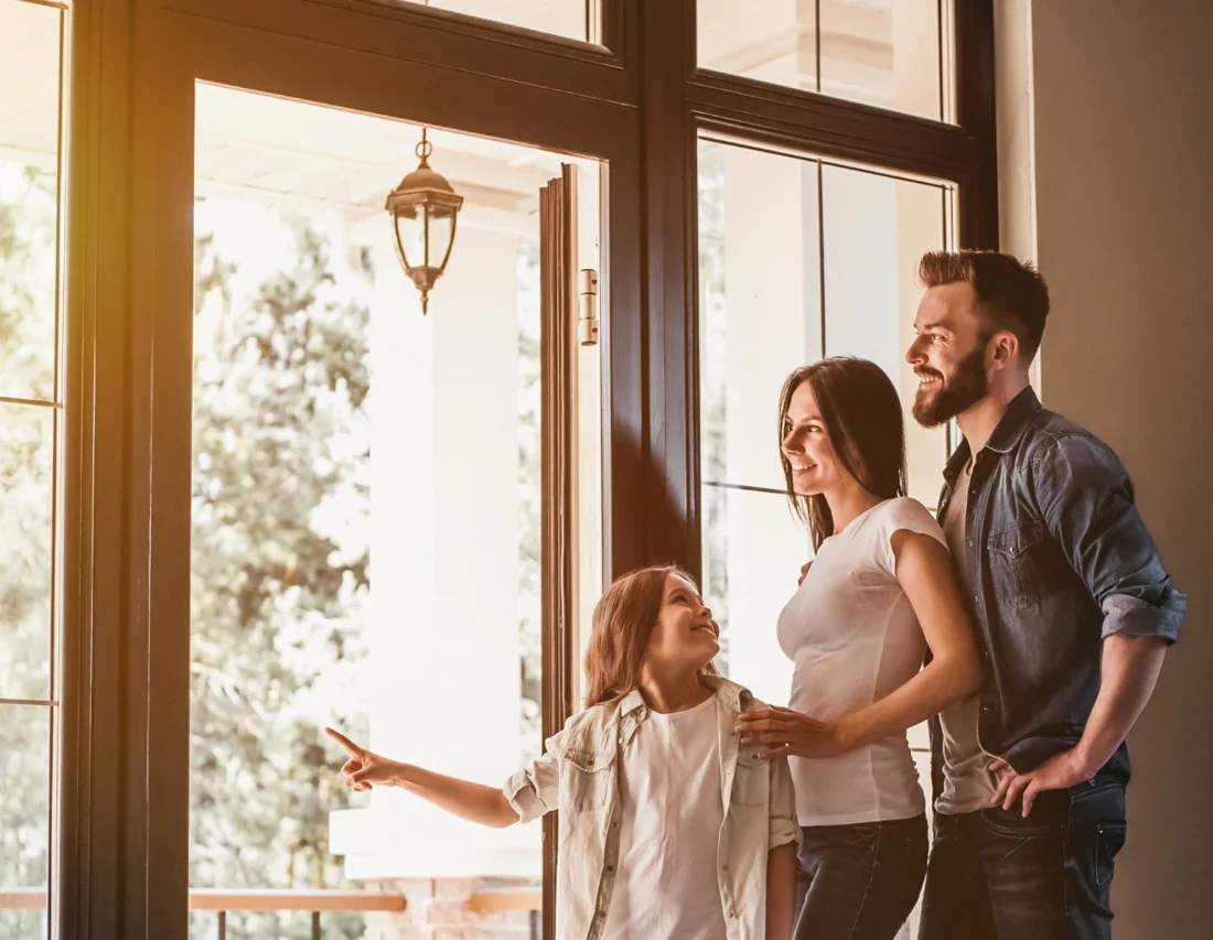 Young family in the doorway of their new home